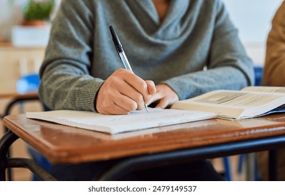 University student, hand and writing in classroom with books for english literature or language for exam. Person, college and scholarship for learning or education, knowledge and study academic work. - Powered by Shutterstock