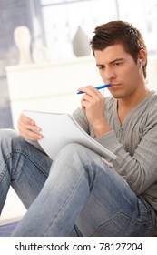 University Student Thinking And Learning From Notes, Holding Pen, Concentrating.?