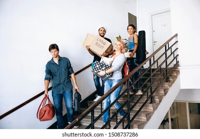 University Students  Moving To New Apartment Carrying Cardboard Box And Stuff. Roommate Friends First Day In College Campus