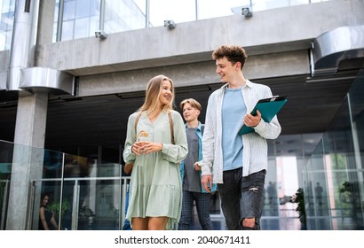 University Students Walking In The Corridor Indoors, Talking.