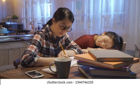 University Young Girl Student Sleeping Sitting At Wooden Table In Home Kitchen At Night By Notebook Computer. Side View Of Asian Hard Working Woman In Glasses Keep Study Concentrated Stay Up Late