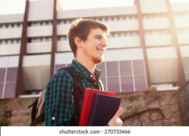 University.Smiling young student man holding a book and a bag on a university background .Young smiling student  outdoors Life style.City.Student. - Shutterstock ID 270733466