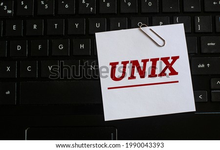 UNIX - word on a white sheet against the background of the laptop keyboard. Internet concept