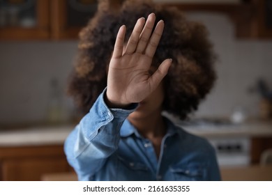 Unknown Afro American Female Stretch Hand To Camera Show Stop No Gesture To Racial Gender Discrimination Harassment Abortion War Genocide. Focus On Open Palm In Front Of Blurred Face Of Young Woman