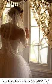 unknown bride is looking out the window and waiting for her spec