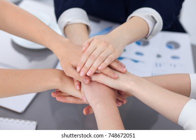 Unknown business people joining hands, close-up. Teamwork concept - Shutterstock ID 748672051