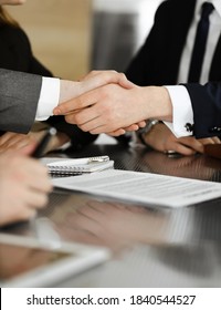Unknown businessman shaking hands with his colleague or partner above the glass desk in modern office, close-up. Business people group at meeting - Shutterstock ID 1840544527