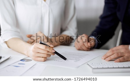 Unknown businessman and woman discussing contract in office. closeup.Business people or lawyers working together at meeting. Teamwork and partnership