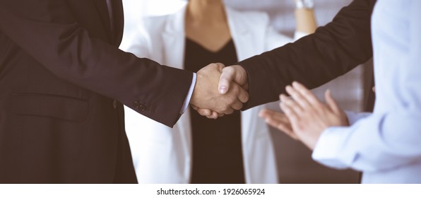 Unknown businesspeople are shaking their hands after signing a contract at meeting, close-up. Business communication concept - Powered by Shutterstock