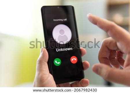 Unknown caller. man holds a phone in his hand and thinks to end the call. Incoming from an unknown number. Incognito or anonymous