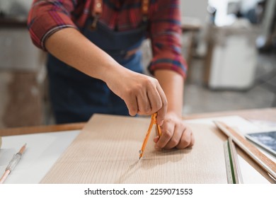 Unknown carpenter use compass math on wood sheet timber at wood factory - Powered by Shutterstock - Get 15% off with code: PIKWIZARD15