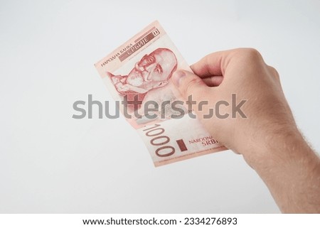 Unknown caucasian man holding 1000 Serbian Dinar RSD banknote money isolated on white background
