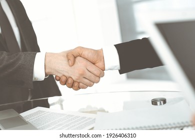 Unbekannte Geschäftsleute schütteln sich die Hände, um das Treffen am Schreibtisch im Büro zu beenden, Nahaufnahme. Handshake-Konzept