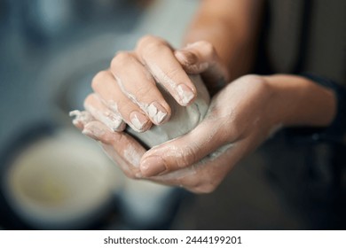 Unknown female hands holding ball made of clay to start working - Powered by Shutterstock