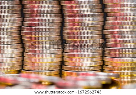 unknown large quantity pile of beautiful old coins with ribbed side, lie together, close-up photo of real metal money illuminated by light