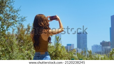 Similar – Brünette Frau, die mit einem Handy einen Fluss fotografiert.