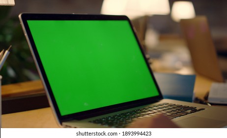 Unknown Male Person Waving Hand While Video Call On Chroma Key Laptop Indoors. Unrecognizable Man Hands Using Green Screen Computer In Office. Incognizable Guy Having Web Conference Inside.