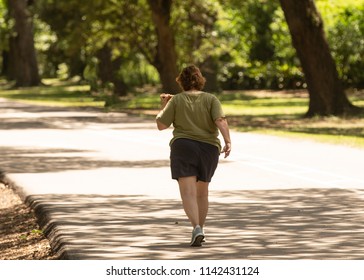 Unknown Obese Woman Is Making Progress Walking In The Park