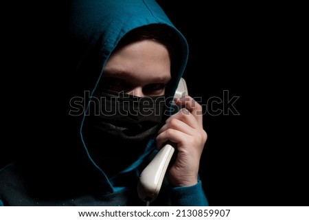 Unknown person with covered face makes an anonymous call intimidating and threatening the interlocutor 商業照片 © 