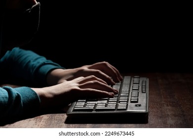 Unknown person hands using a keyboard sends message with intimidating and threatening to the interlocutor