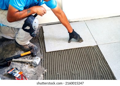 unknown senior tile installer or worker working in house, hands view