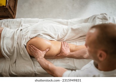 Unknown woman lying while have back leg massage by male caucasian therapist at beauty spa treatments salon healthcare relaxation concept copy space