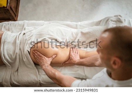 Unknown woman lying while have back leg massage by male caucasian therapist at beauty spa treatments salon healthcare relaxation concept copy space