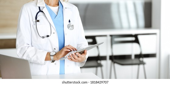 Unknown woman-doctor at work in clinic. Female physician using tablet computer, close-up. Medicine concept - Shutterstock ID 1818429707
