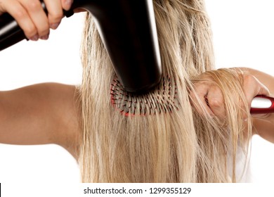 unknown young woman drying her hair with hair dryer on white backgrund