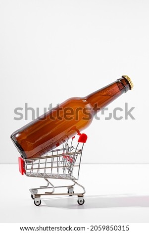 Unlabelled bottle of beer in tiny metal shopping cart