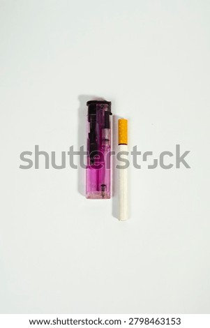 Unlit cigarette placed vertically next to a pink plastic lighter on a white background with cigarette nicotine addiction