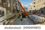 Unloading concrete plates from truck by crane at road construction site timelapse. Industrial workers with hardhats and uniform