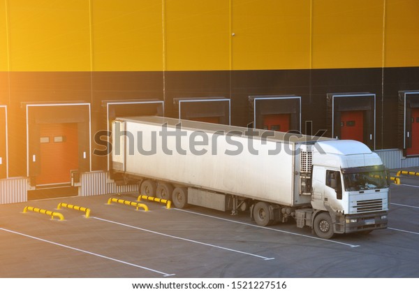 Unloading trucks at a modern warehouse complex.\
Logistics. Flare