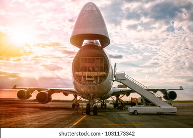 Unloading wide body transport cargo aircraft in the morning sun - Shutterstock ID 1031173342