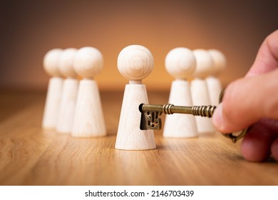 Unlock potential - motivational concept. Manager (HR specialist) unlock leader potential represented by figurine and hand with key. - Shutterstock ID 2146703439