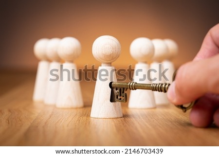 Unlock potential - motivational concept. Manager (HR specialist) unlock leader potential represented by figurine and hand with key.