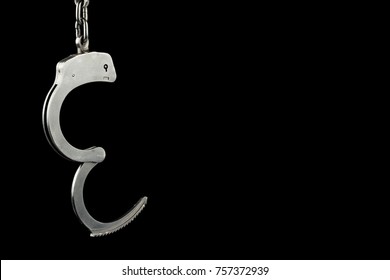 Unlocked police handcuffs on a black background with text / writing / copy space