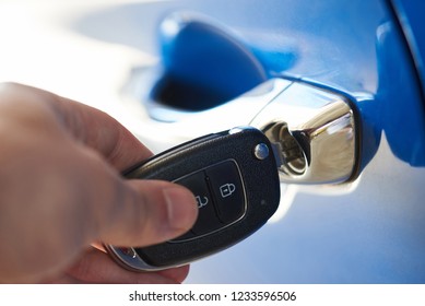 Unlocking blue car door with key close up - Powered by Shutterstock