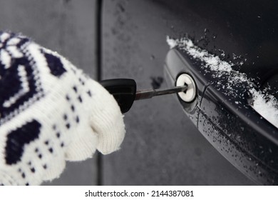 Unlocking The Car Door Lock With A Key - Woman Hand In A Winter Glove Close Up