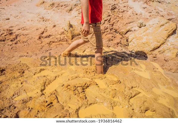 Unlucky buried person standing in natural\
quicksand river, clay sediments, sinking, drowning quick sand,\
stuck in the soil, trapped and stuck\
concept
