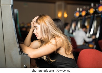 Unlucky Woman Looking Sad And Stressed After Losing All Her Money In A Slot Machine In A Casino