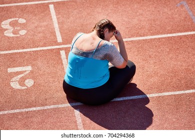 Unlucky Woman Sitting On Stadium Racetrack After Hard Workout