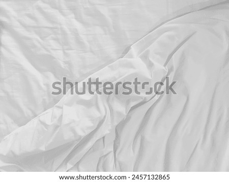 Unmade bedding sheets top view background. White wrinkled blanket after sleeping. Messy duvet. Cozy fabric surface. Untidy bedspread backdrop.