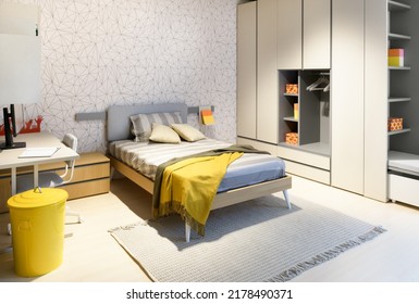 Unmade Comfortable Bed Located Between Desk With Computer And Wardrobe In Contemporary Kid Bedroom