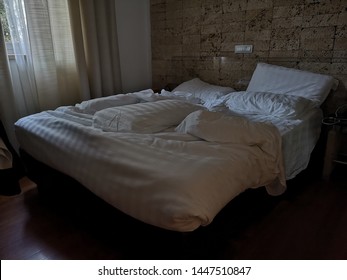 Unmade Double Bed In The Hotel