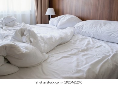 Unmade Double Bed With White Linen In The Morning