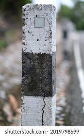 An Unnamed Mile Marker Aside Of A Small Rural Road