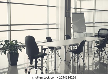 Unoccupied office space with table, chairs and white board near big window - Shutterstock ID 1054114286