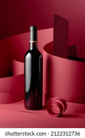 An Unopened Bottle Of Red Wine On A Red Background.