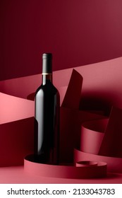 An Unopened Bottle Of Red Wine On A Red Background.